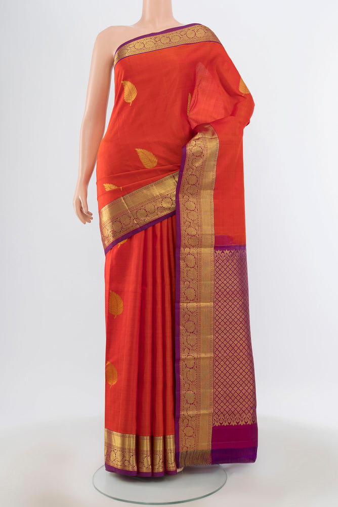 Brick Orange Kanchipuram Silk Saree with Plain Body and Silk Border.  displayed on a mannequin