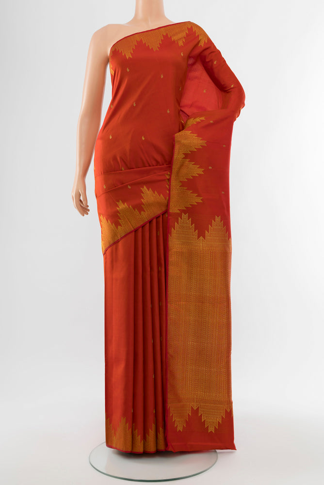 Rust Kanchipuram Silk Saree with Zari Butta on the body and Silk Border.  displayed on a mannequin