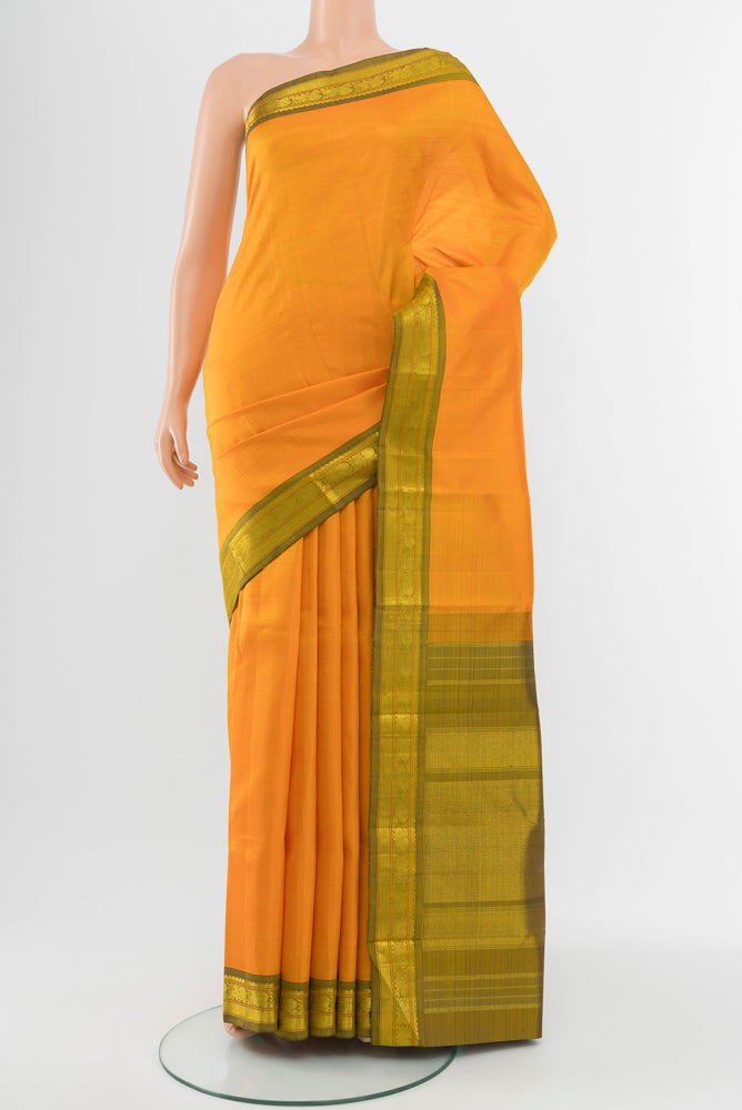 Yellow Kanchipuram Silk Saree with Zari Butta on the body and Silk Border.  displayed on a mannequin