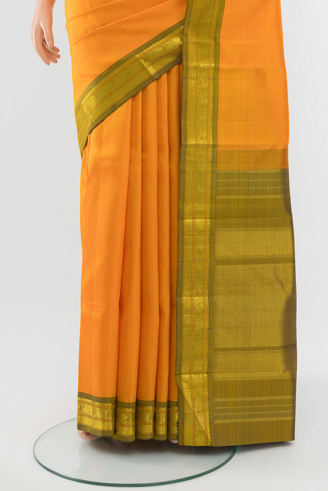 Pleats and pallu of Yellow Kanchipuram Silk Saree with Zari Butta on the body and Silk Border. 