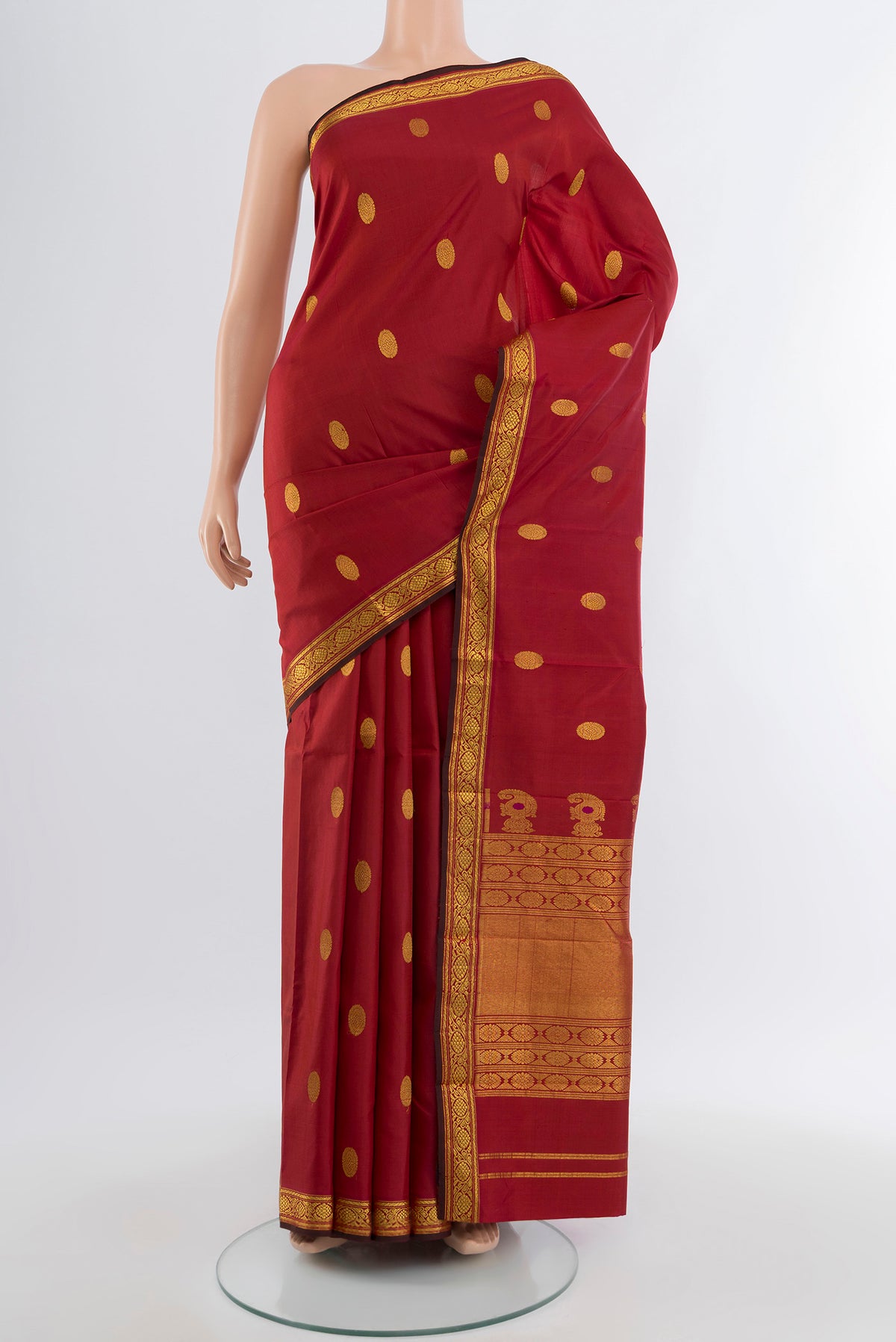 Maroon Kanjivaram Silk Saree with Zari Butta on the body and Silk Border.  displayed on a mannequin