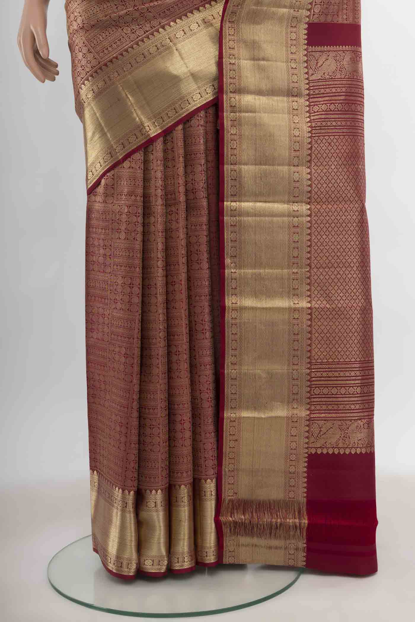 Pleats and pallu of Maroon Kanchipuram Silk Saree with Zari Butta on the body and Silk Border. 