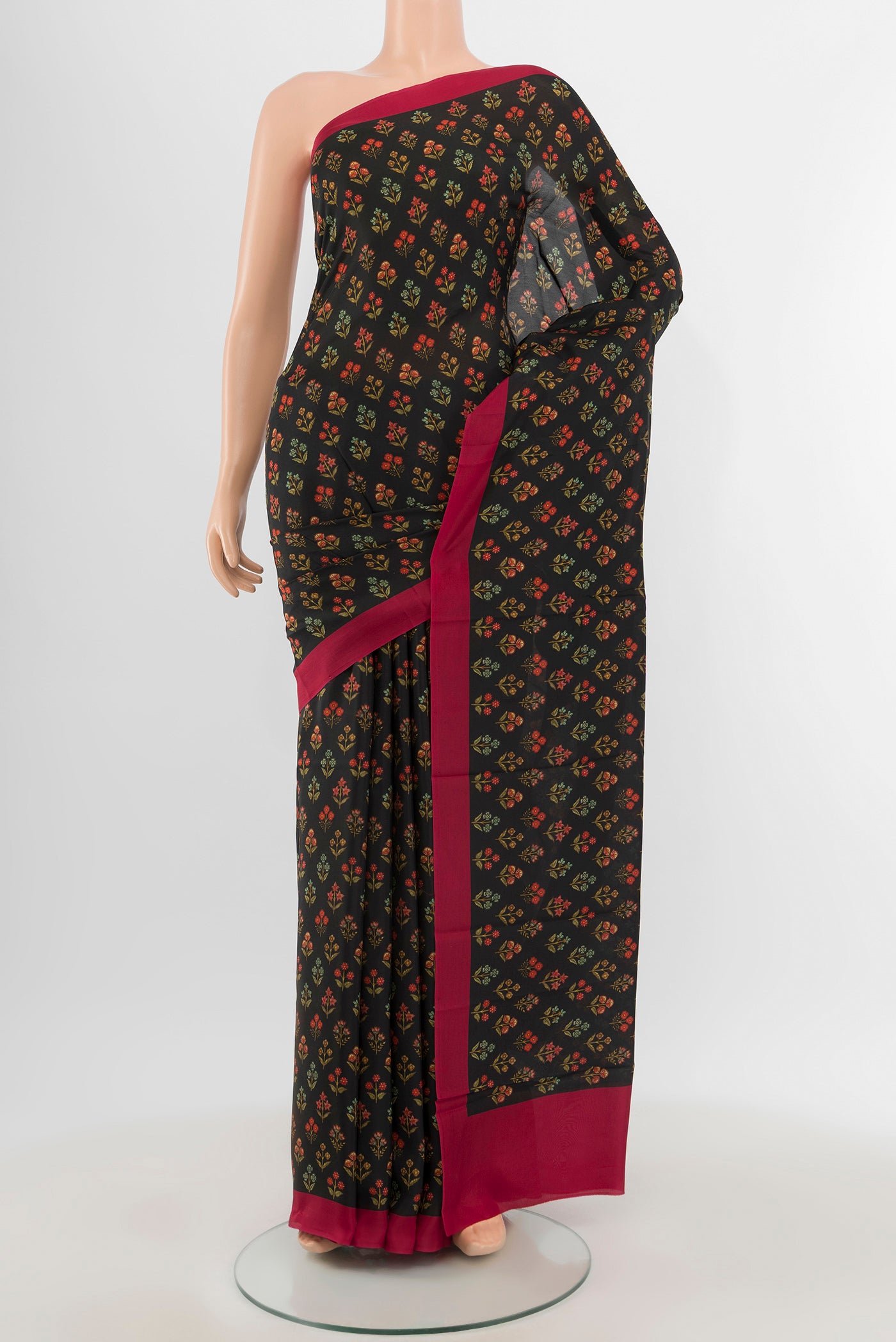 Black Printed Silk Saree with Floral Print on the body and Printed Border.  displayed on a mannequin