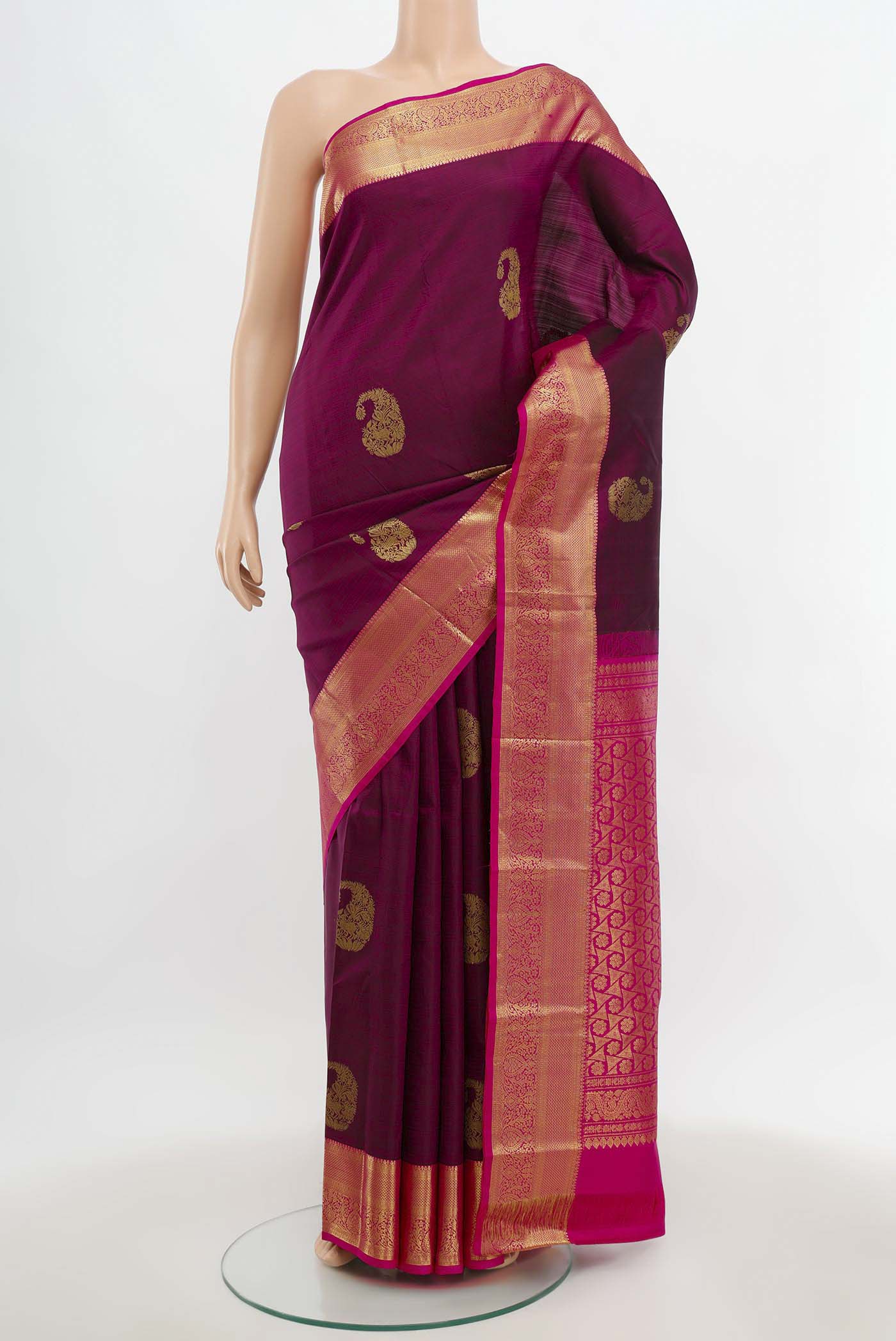 Magenta Kanchipuram Silk Saree with Zari Butta on the body and Silk Border.  displayed on a mannequin