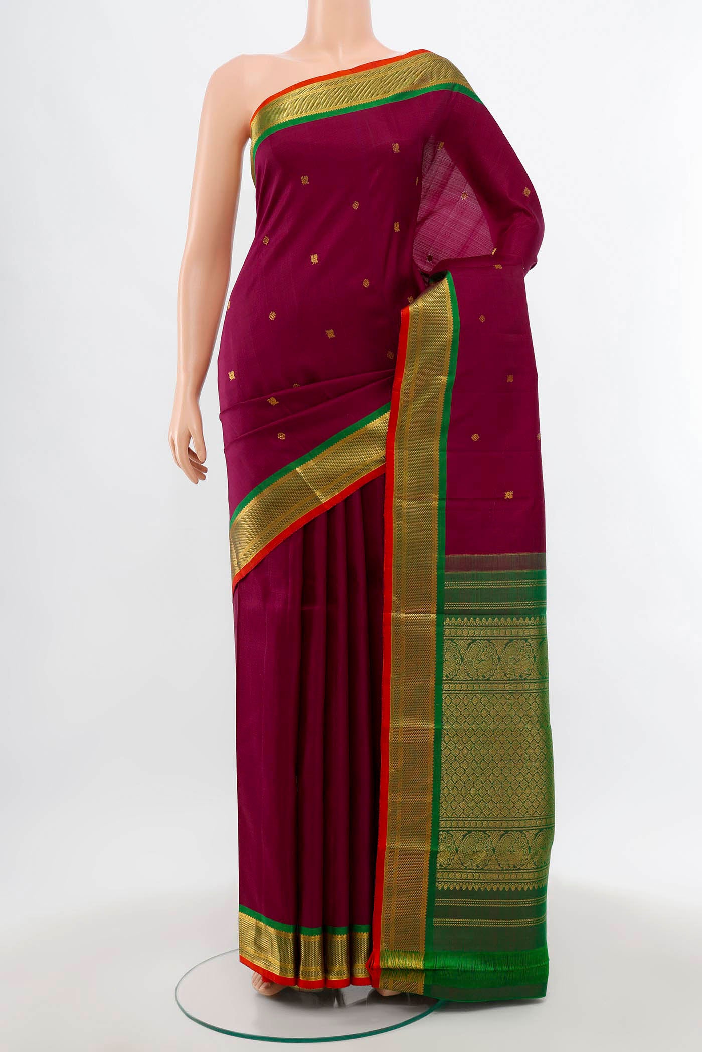Maroon Kanchipuram Silk Saree with Zari Butta on the body and Silk Border.  displayed on a mannequin