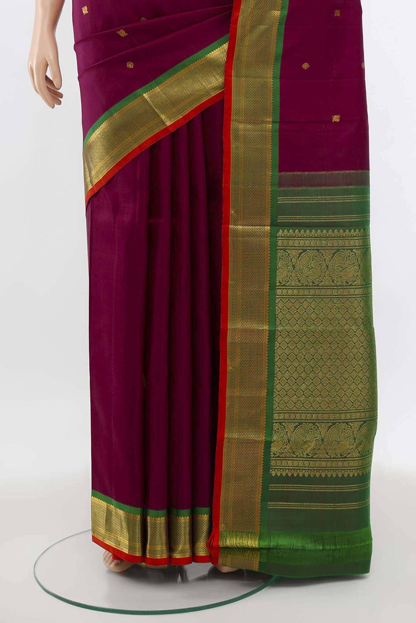 Pleats and pallu of Maroon Kanchipuram Silk Saree with Zari Butta on the body and Silk Border. 