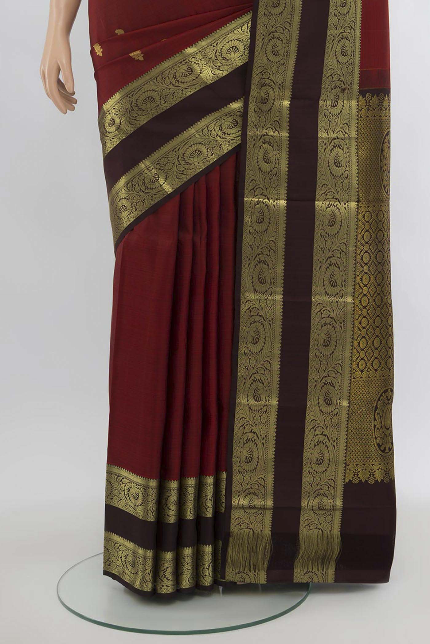 Pleats and pallu of Maroon Kanchipuram Silk Saree with Zari Butta on the body and Silk Border. 