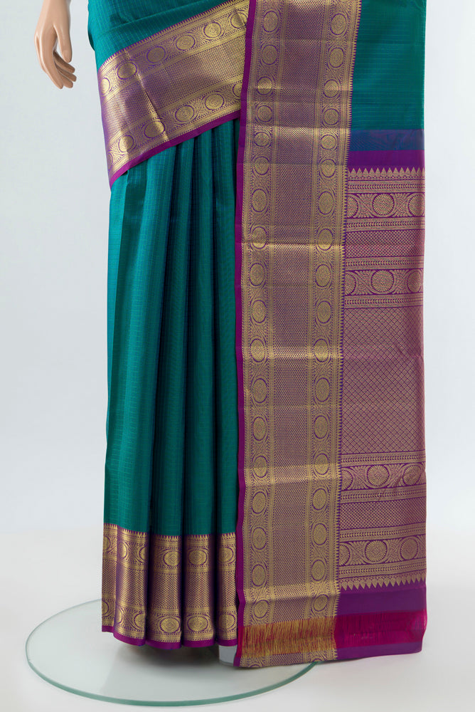 Pleats and pallu of Peacock Blue Kanjivaram Silk Saree with Zari Butta on the body and Silk Border. 