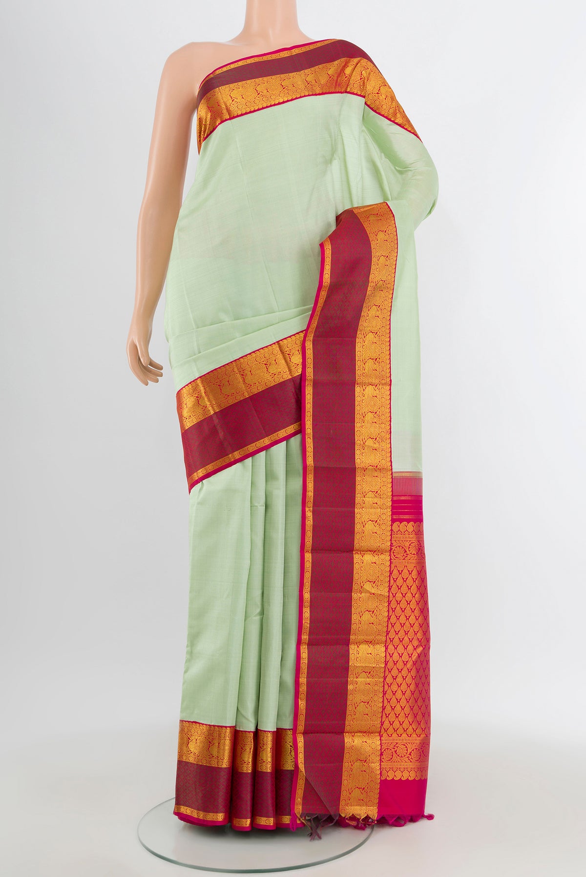 Pista Green Kanjivaram Silk Saree with Plain Body and Zari Border.  displayed on a mannequin
