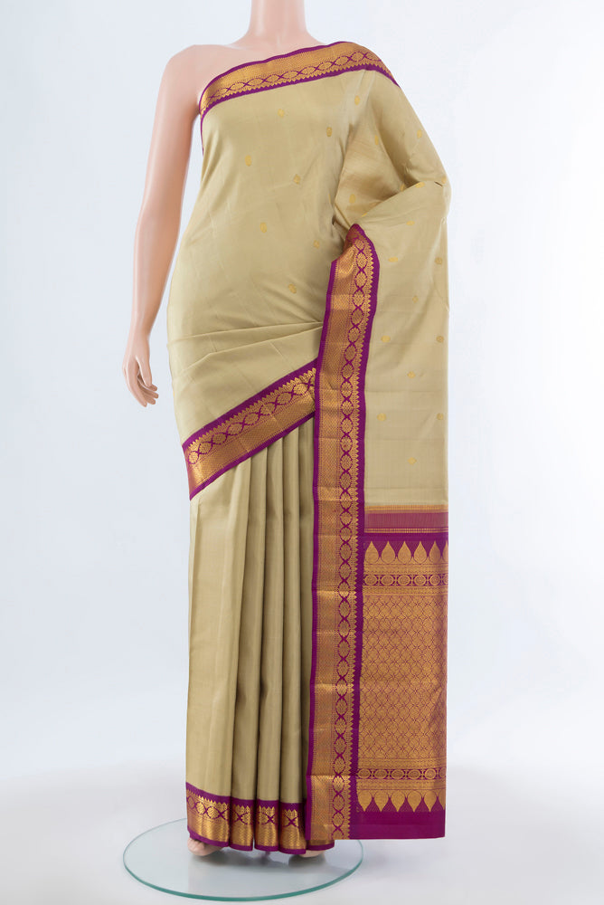 Beige Kanchipuram Silk Saree with Zari Butta on the body and Silk Border.  displayed on a mannequin