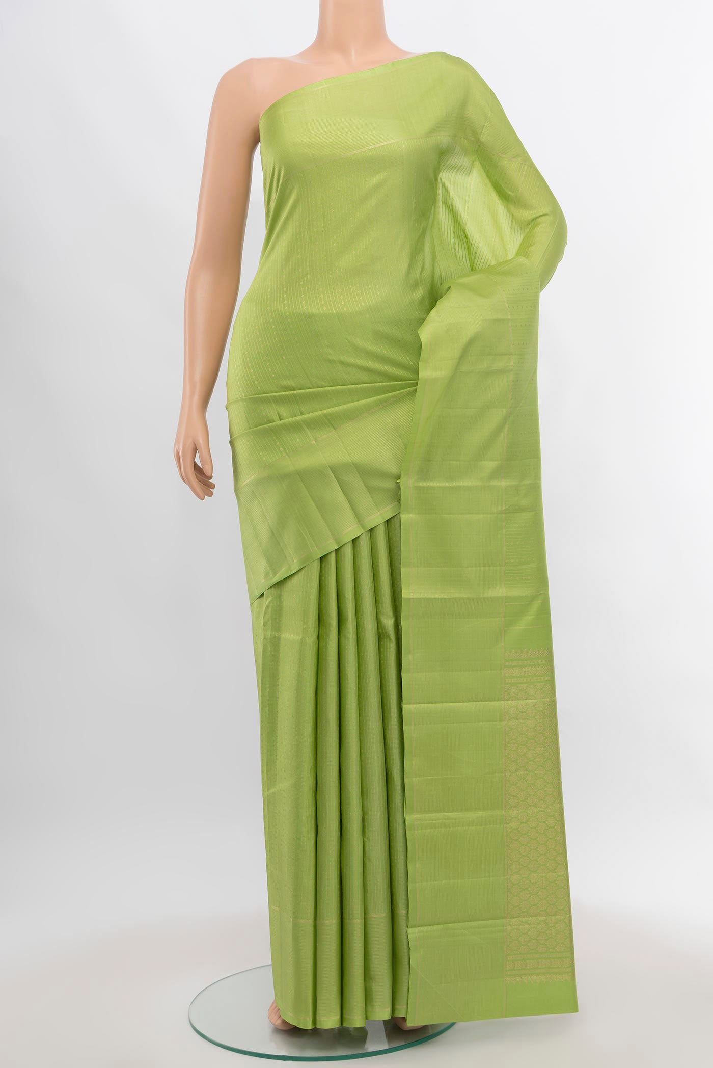 Pista Green Kanchipuram Silk Saree with Zari Butta on the body and Silk Border.  displayed on a mannequin