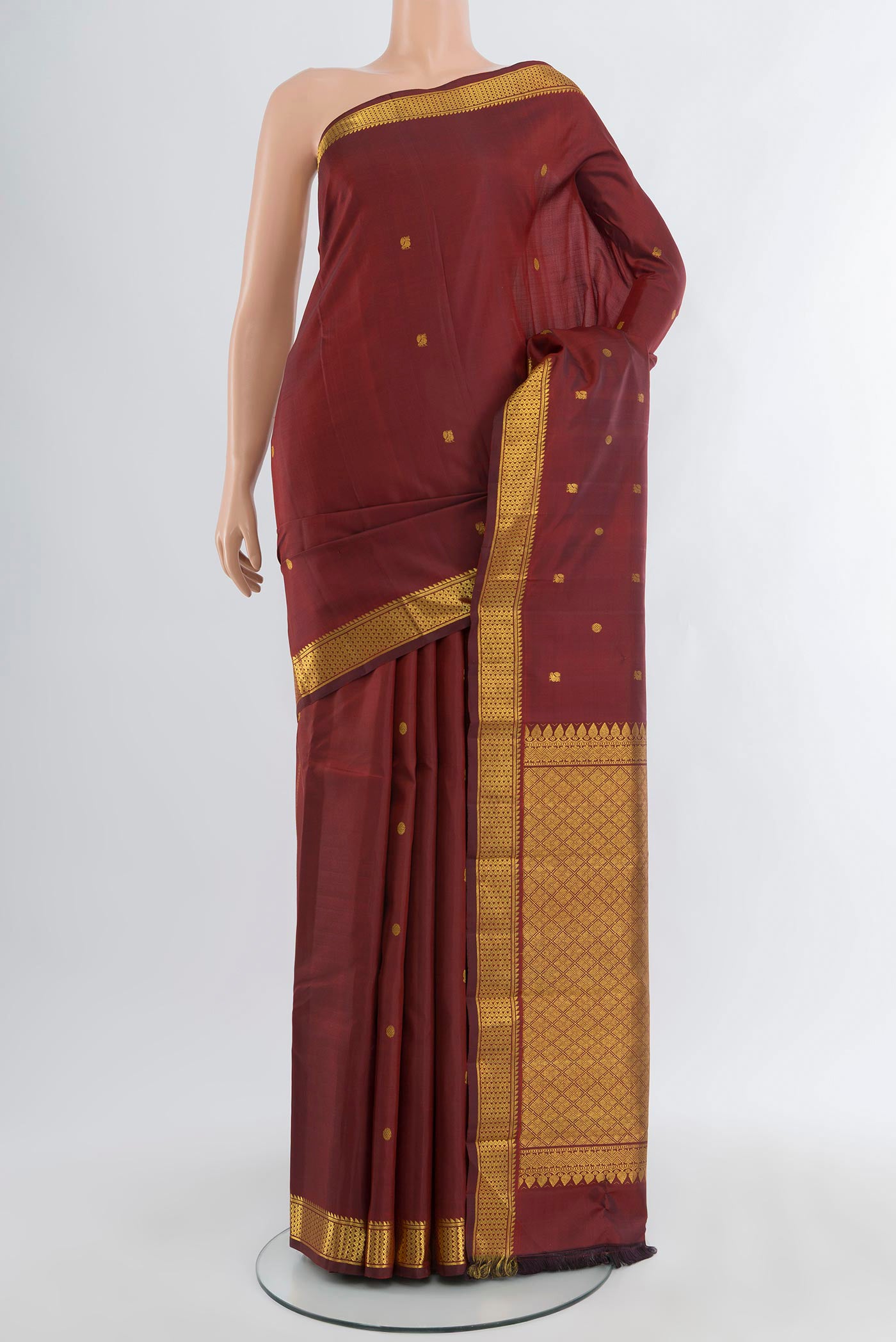 Maroon Kanchipuram Silk Saree with Zari Butta on the body and Zari Border.  displayed on a mannequin
