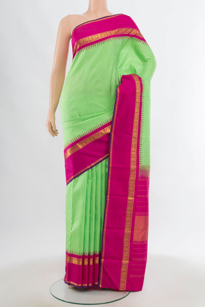Light Green Kanjivaram Silk Saree with Zari Butta on the body and Silk Border.  displayed on a mannequin