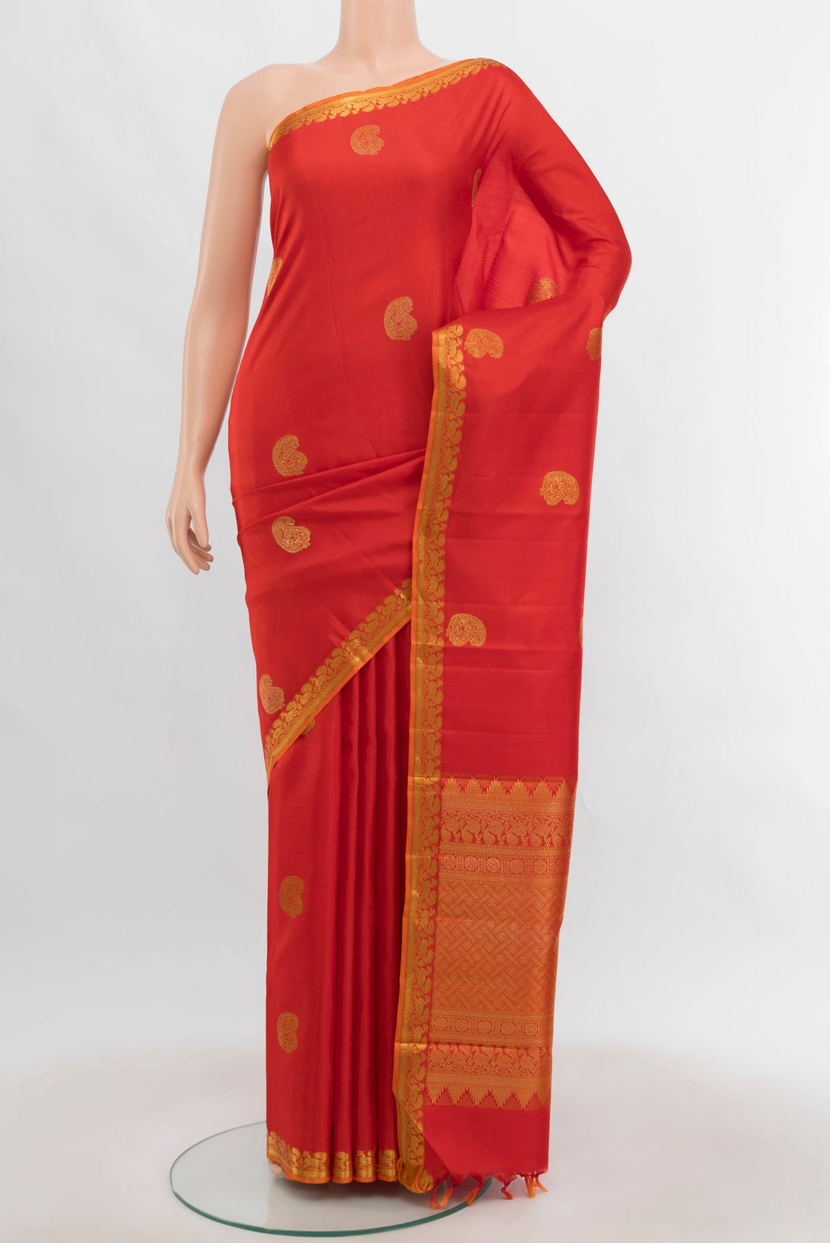 Orange Kanjivaram Silk Saree with Zari Butta on the body and Zari Border.  displayed on a mannequin