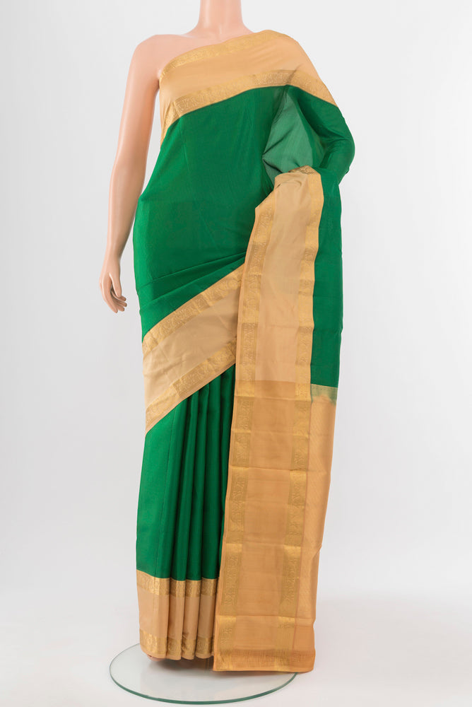 Bottle Green Kanchipuram Silk Saree with Zari Butta on the body and Silk Border.  displayed on a mannequin