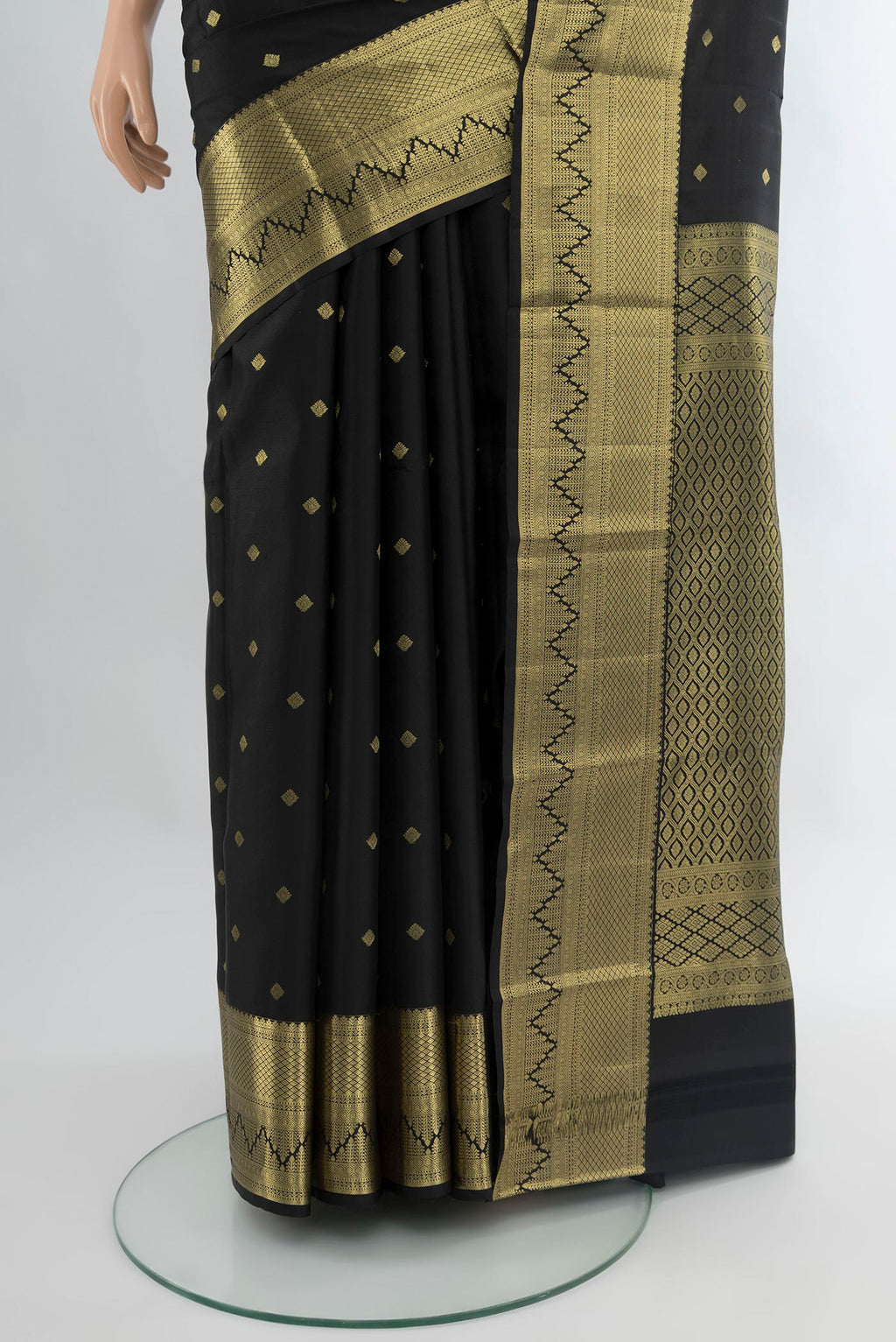 Pleats and pallu of Black Kanchipuram Silk Saree with Zari Butta on the body and Zari Border. 