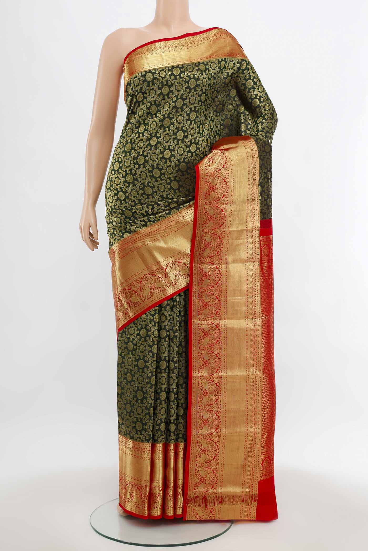Bottle Green Kanchipuram Silk Saree with Zari Butta on the body and Silk Border.  displayed on a mannequin