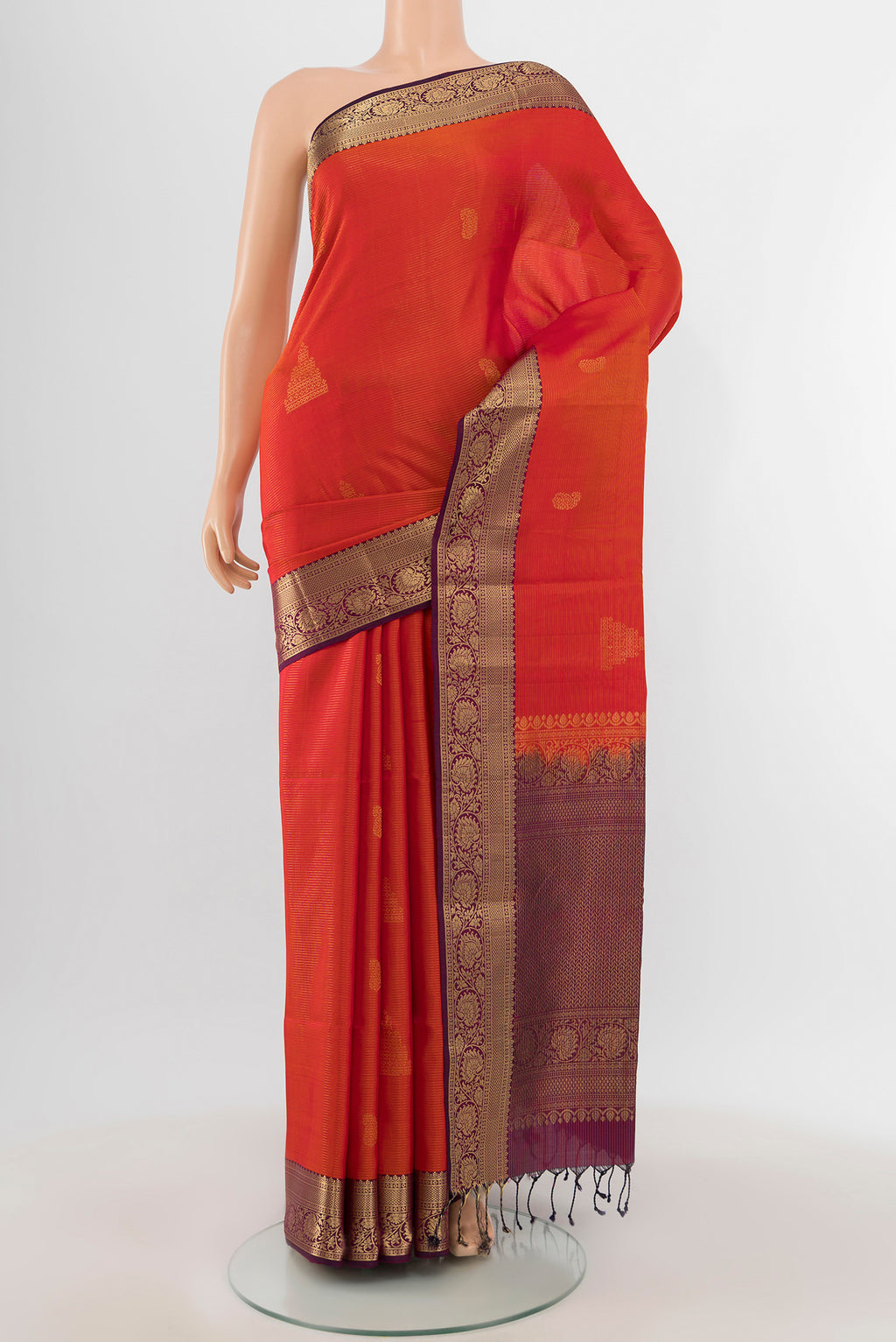 Brick Orange Soft Silk Saree with Zari Butta on the body and Zari Border.  displayed on a mannequin