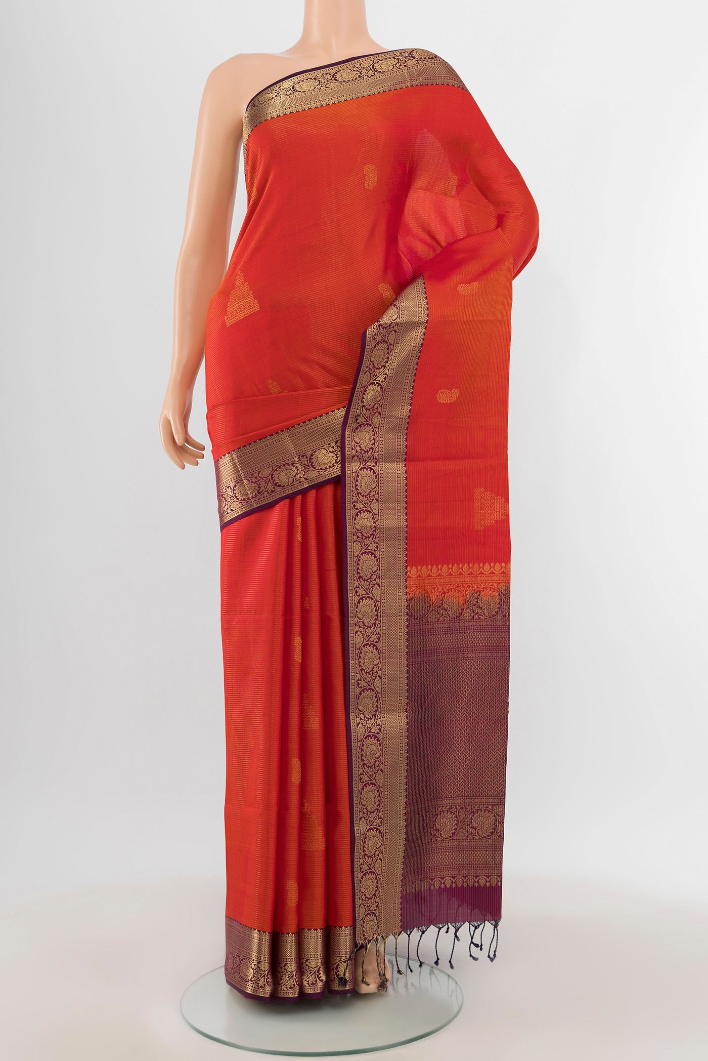 Brick Orange Soft Silk Saree with Zari Butta on the body and Zari Border.  displayed on a mannequin
