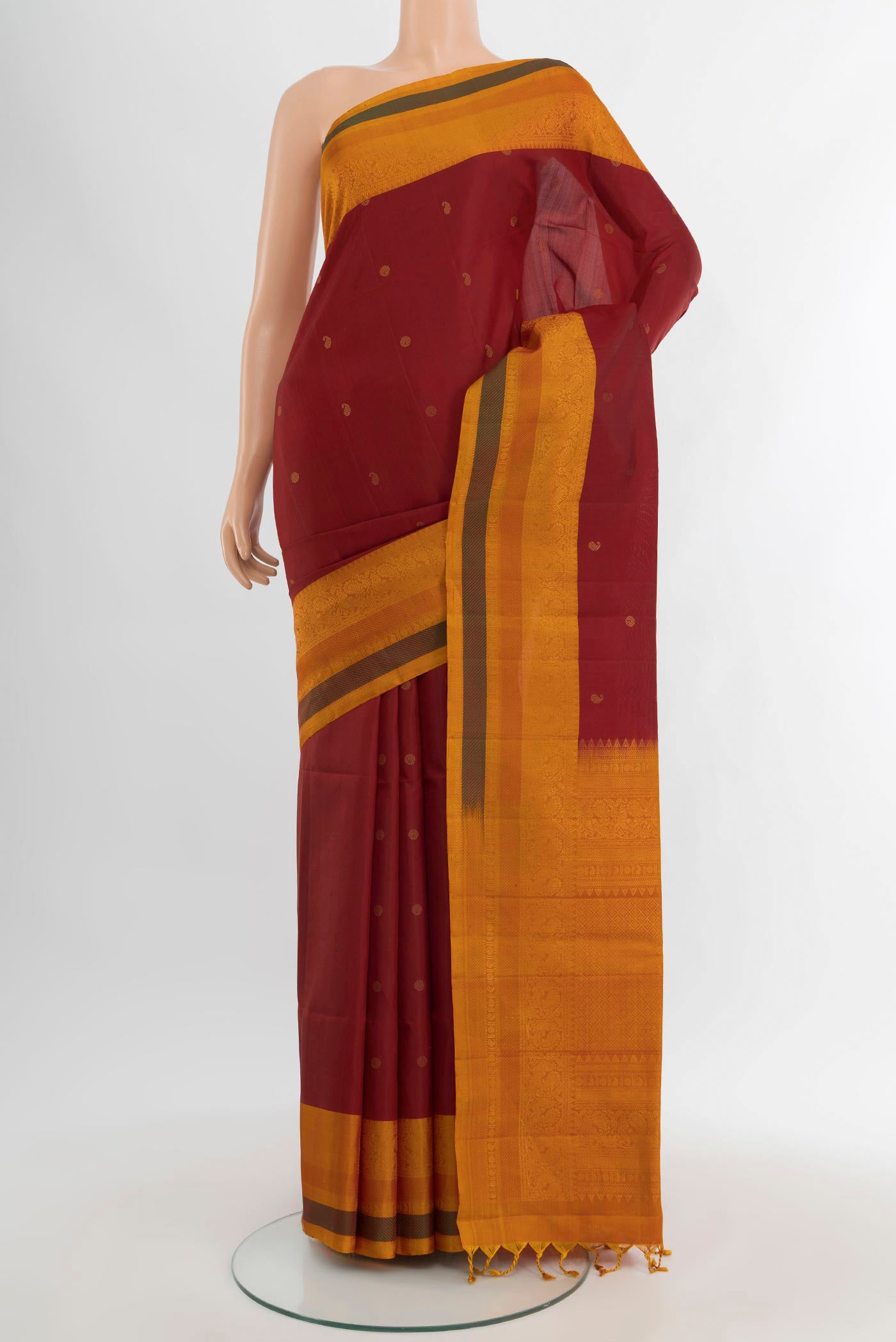 Maroon Soft Silk Saree with Zari Butta on the body and Fancy Border.  displayed on a mannequin