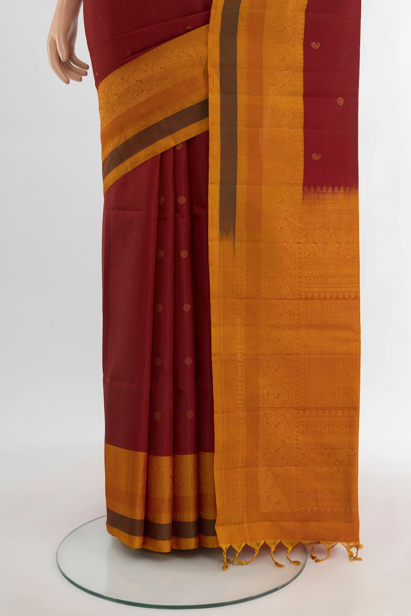 Pleats and pallu of Maroon Soft Silk Saree with Zari Butta on the body and Fancy Border. 