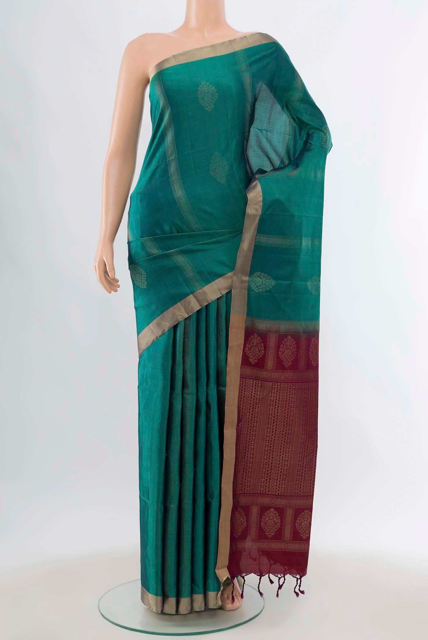 Peacock Blue Soft Silk Saree with Zari Butta on the body and Zari Border displayed on a mannequin