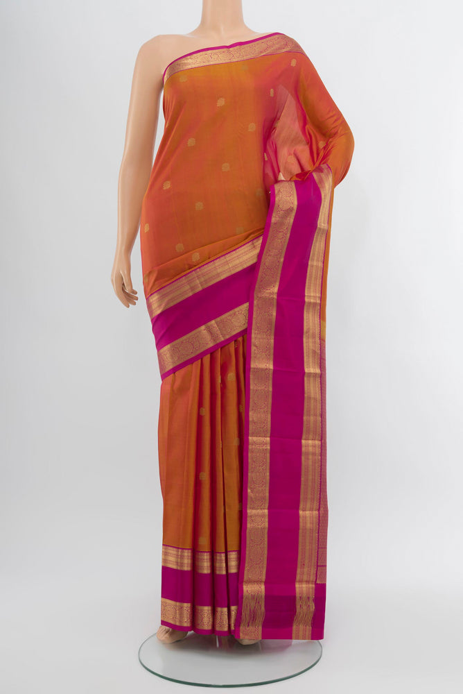 Peach Kanchipuram Silk Saree with Zari Butta on the body and Silk Border.  displayed on a mannequin
