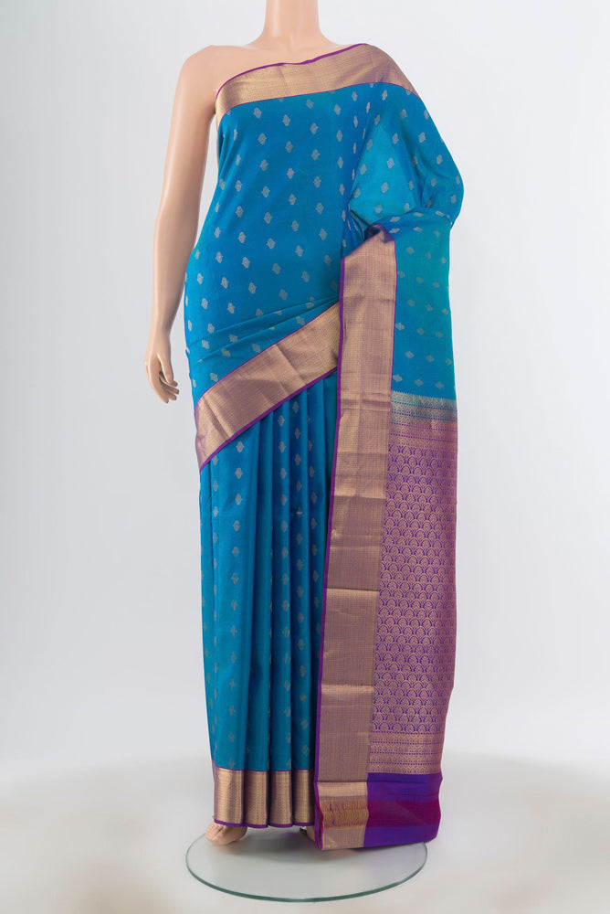 Peacock Blue Kanchipuram Silk Saree with Zari Butta on the body and Silk Border.  displayed on a mannequin