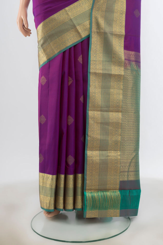 Pleats and pallu of Purple Kanchipuram Silk Saree with Zari Butta on the body and Silk Border. 
