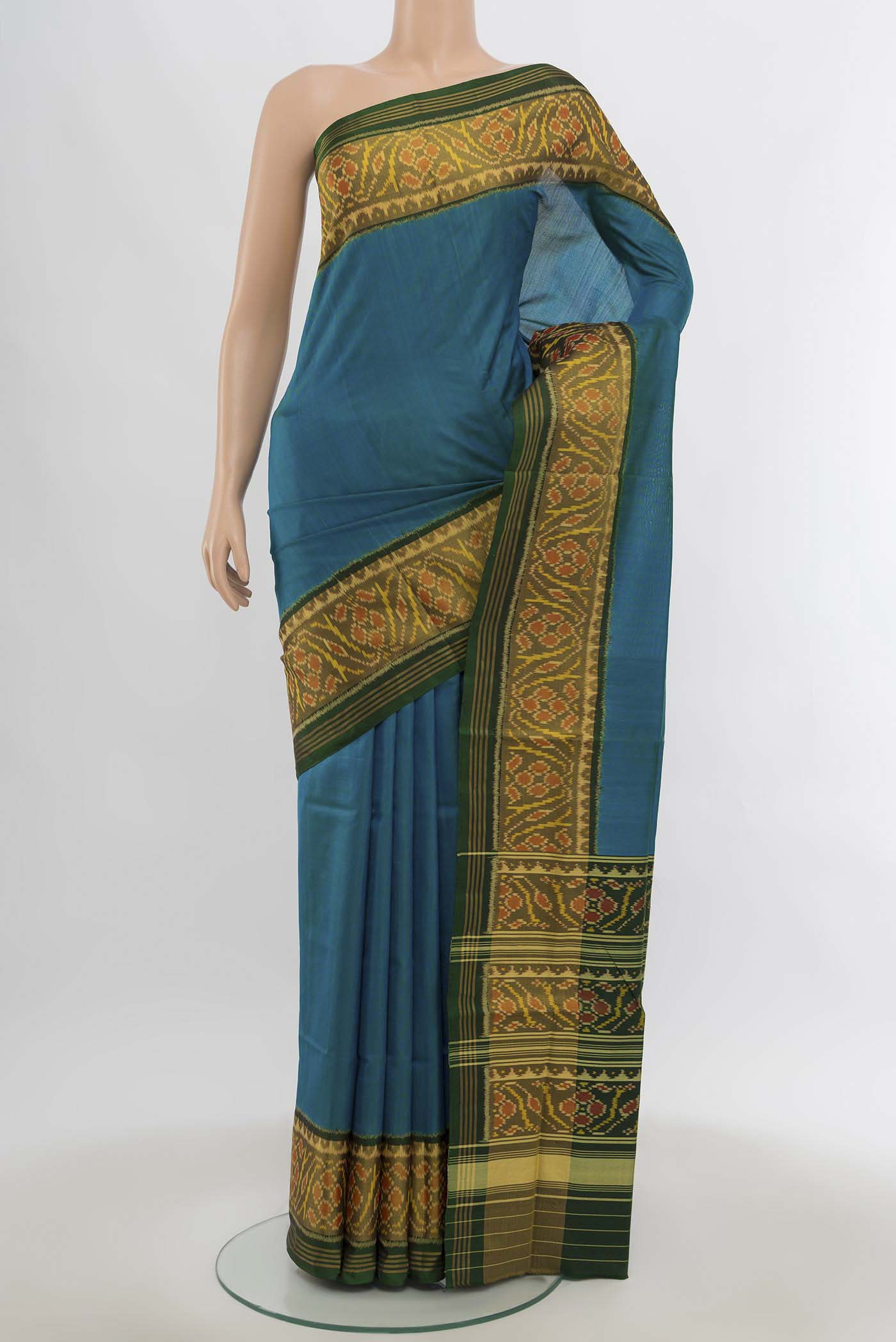 Bottle Green Rajkot Patola Silk Saree with Zari Butta on the body and Silk Border.  displayed on a mannequin