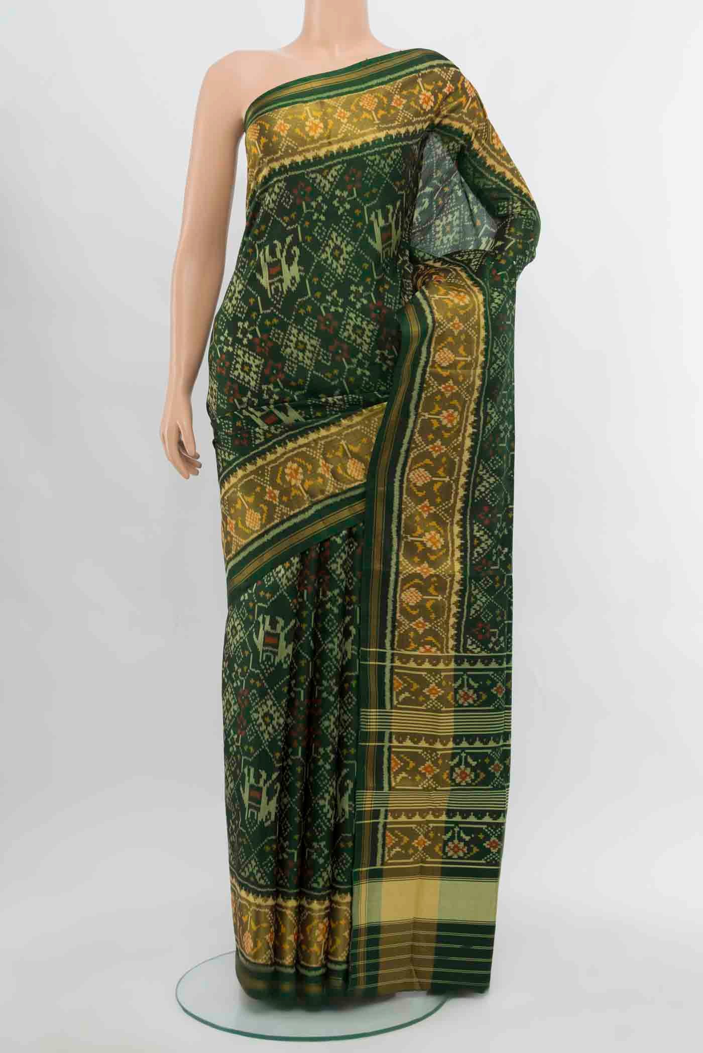Bottle Green Rajkot Patola Silk Saree with Zari Butta on the body and Silk Border.  displayed on a mannequin