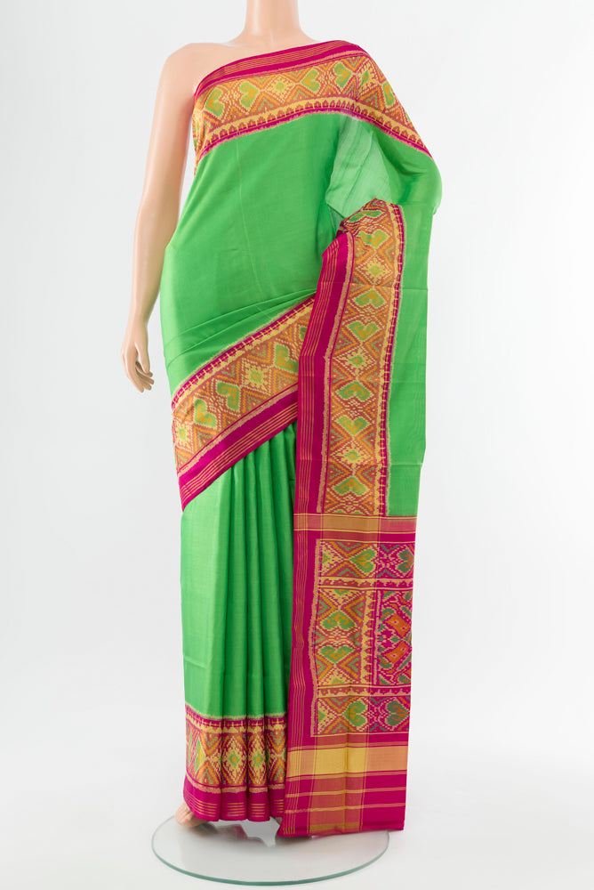Parrot Green Rajkot Patola Silk Saree with Batik Print on the body and Silk Border.  displayed on a mannequin