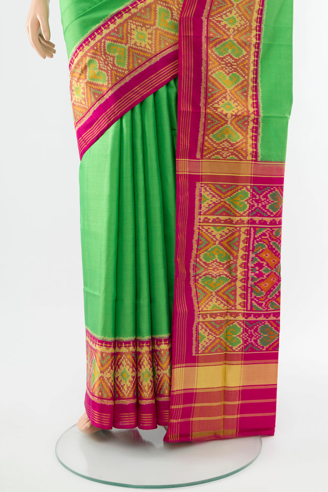 Pleats and pallu of Parrot Green Rajkot Patola Silk Saree with Batik Print on the body and Silk Border. 