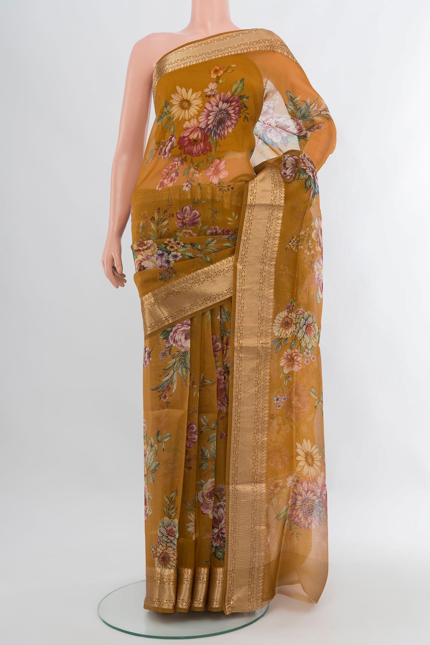 Mustard Organza Silk Saree with Floral Print on the body and Zari Border.  displayed on a mannequin