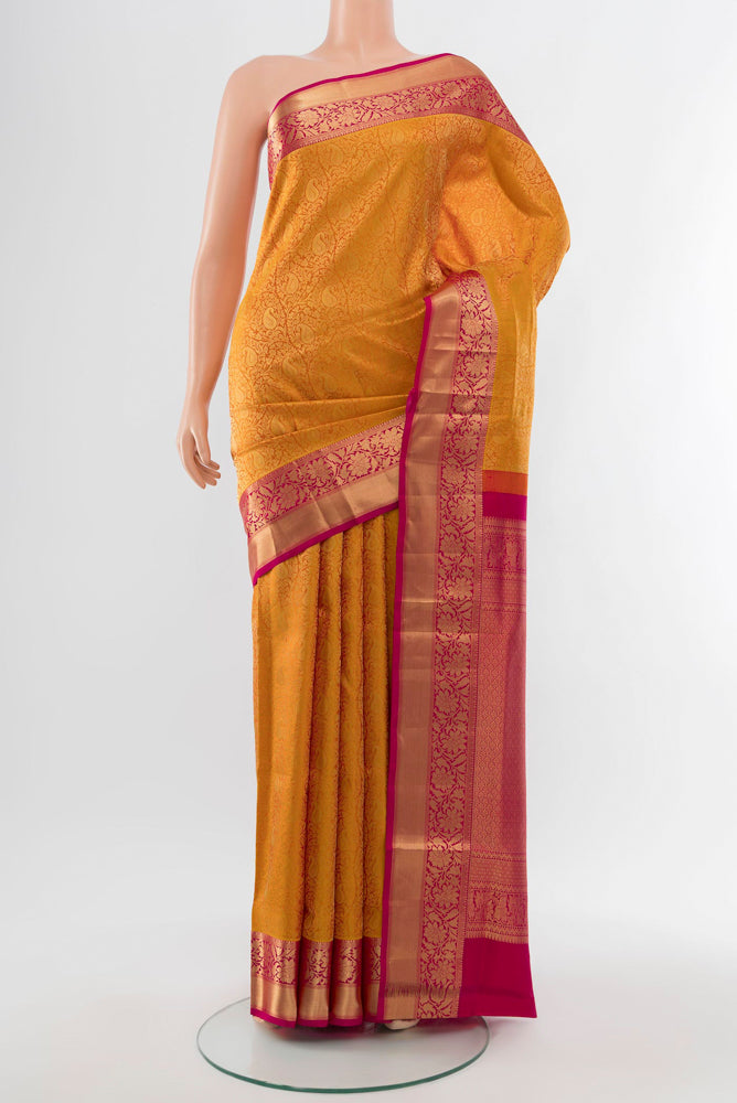 Golden Kanchipuram Silk Saree with Zari Butta on the body and Silk Border.  displayed on a mannequin