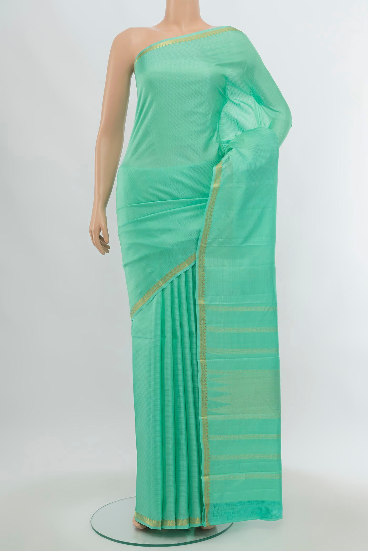 Sage Green Soft Silk Saree with Zari Butta on the body and Silk Border.  displayed on a mannequin