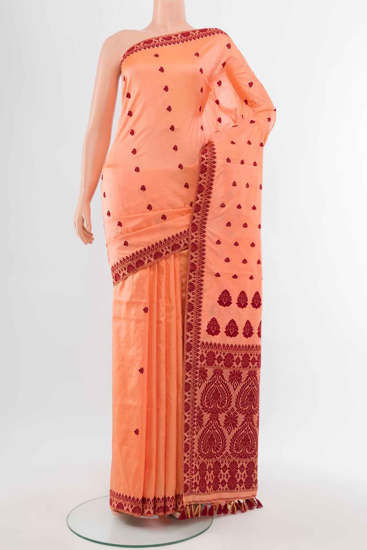 Orange Assam Silk Saree with Jacquard With Thread Butta on the body and Silk Border.  displayed on a mannequin