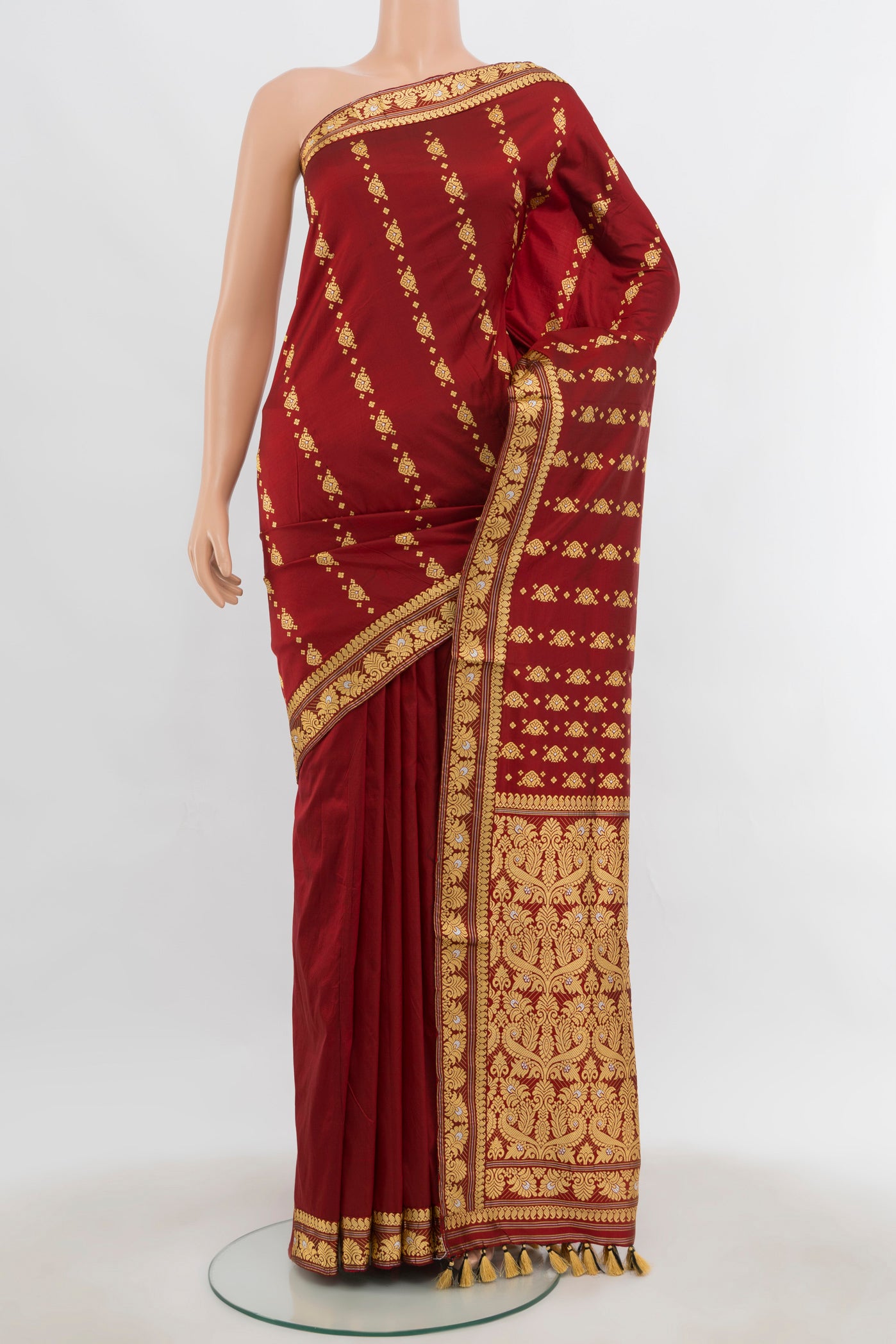 Maroon Assam Silk Saree with Thread Butta on the body and Silk Border.  displayed on a mannequin