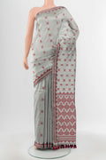 Grey Assam Silk Saree with Zari Butta on the body and Silk Border.  displayed on a mannequin
