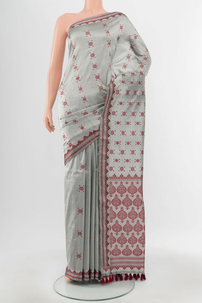 Grey Assam Silk Saree with Zari Butta on the body and Silk Border.  displayed on a mannequin