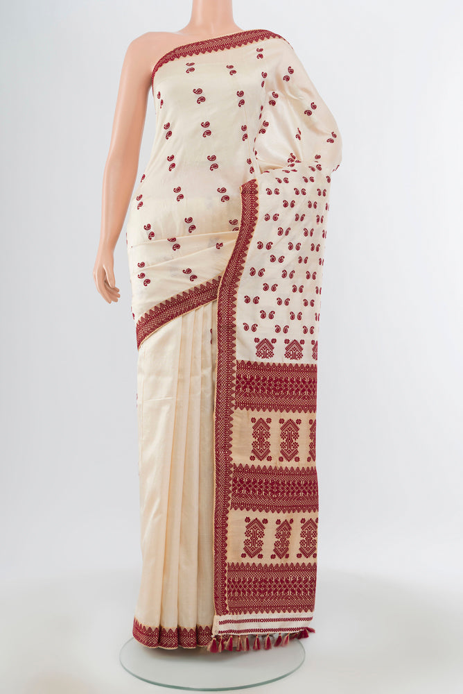 Cream Assam Silk Saree with Jacquard With Thread Butta on the body and Silk Border.  displayed on a mannequin