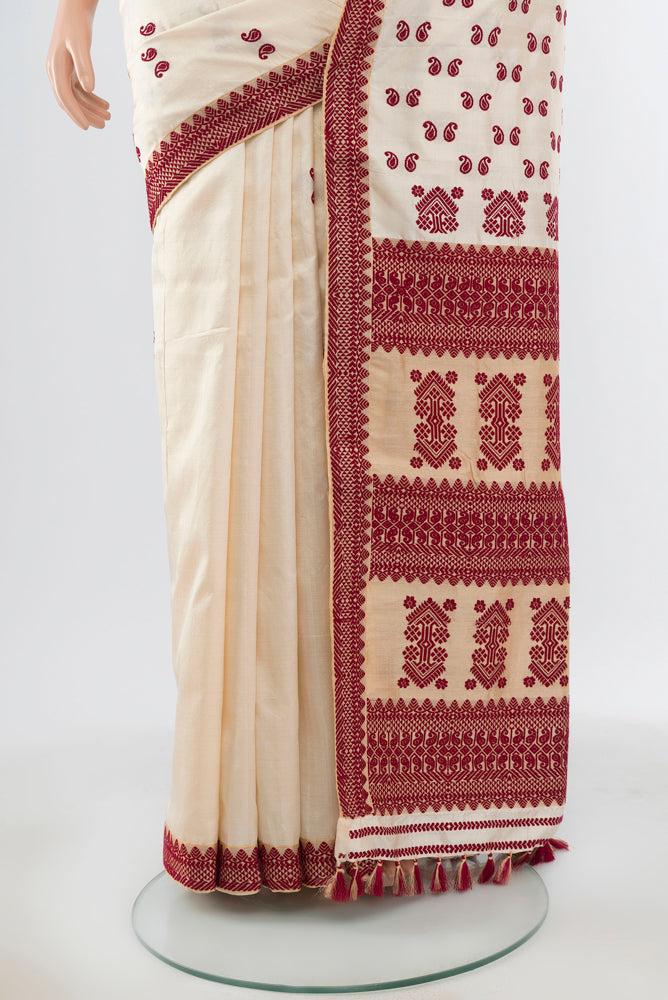 Pleats and pallu of Cream Assam Silk Saree with Jacquard With Thread Butta on the body and Silk Border. 