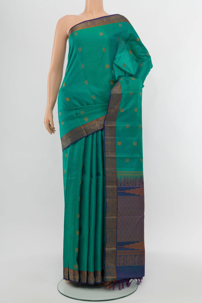 Peacock Blue Kanchipuram Silk Saree with Zari Butta on the body and Silk Border.  displayed on a mannequin