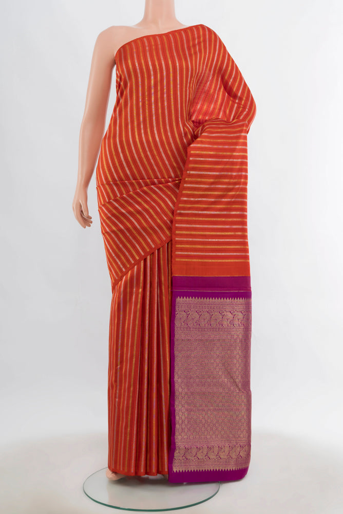 Rust Kanchipuram Silk Saree with Zari Butta on the body and Fancy Border.  displayed on a mannequin