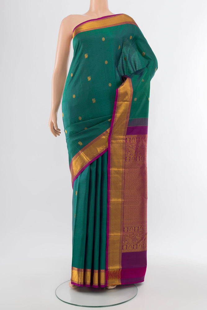 Peacock Blue Kanchipuram Silk Saree with Zari Butta on the body and Silk Border.  displayed on a mannequin