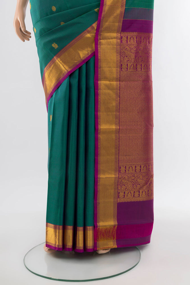 Pleats and pallu of Peacock Blue Kanchipuram Silk Saree with Zari Butta on the body and Silk Border. 