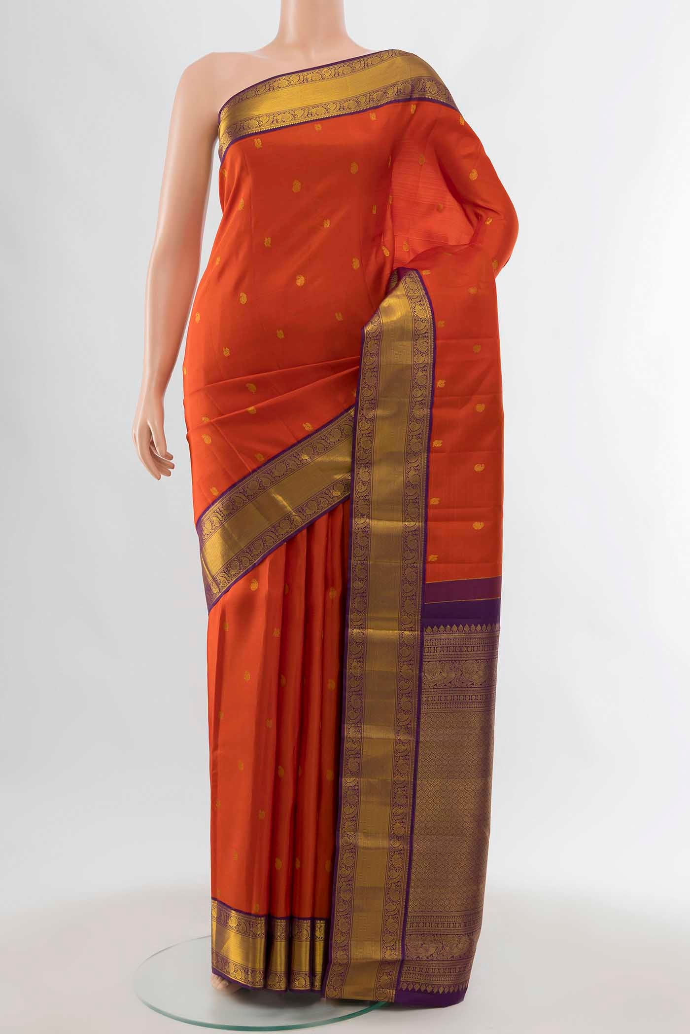 Orange Kanchipuram Silk Saree with Zari Butta on the body and Zari Border displayed on a mannequin