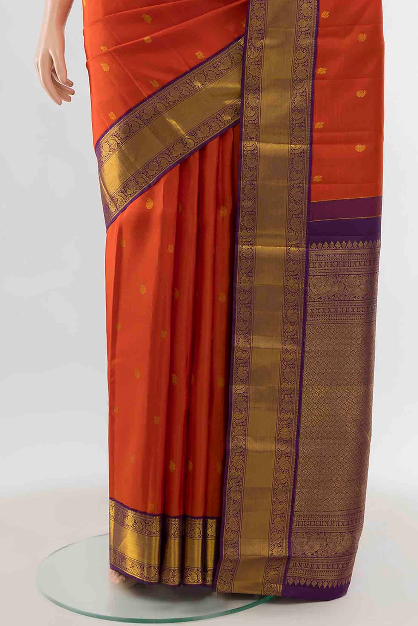 Pleats and pallu of Orange Kanchipuram Silk Saree with Zari Butta on the body and Zari Border