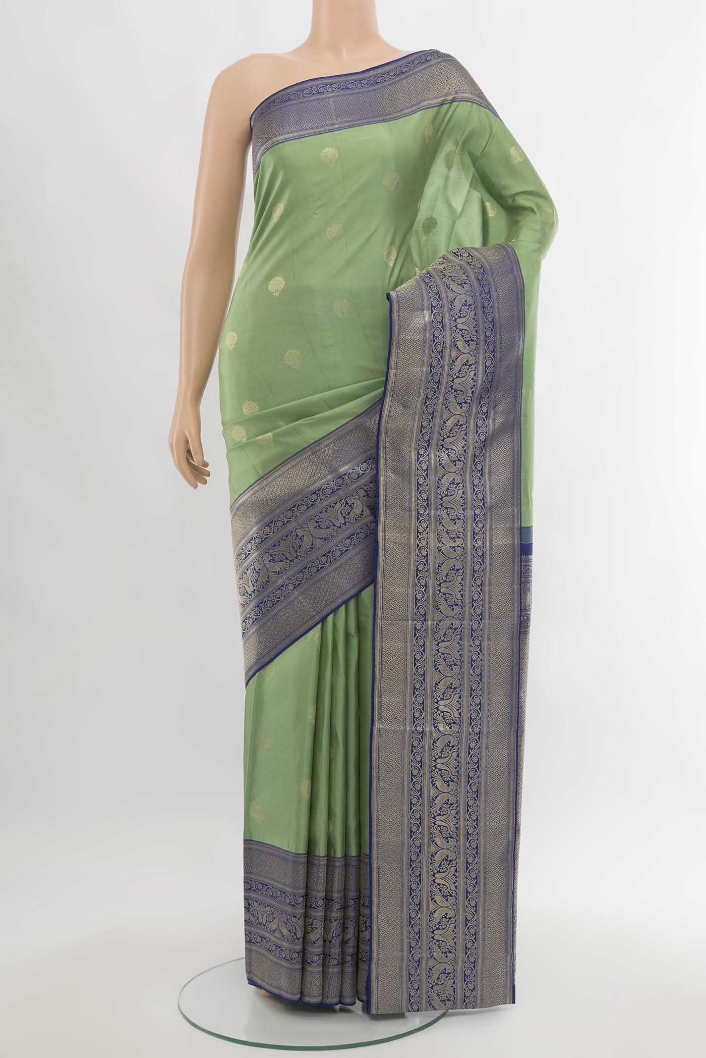 Pista Green Kanjivaram Silk Saree with Zari Butta on the body and Silk Border.  displayed on a mannequin