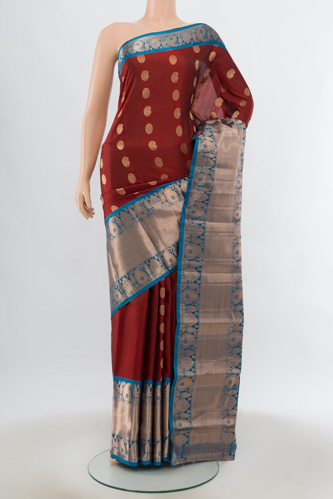 Maroon Kanchipuram Silk Saree with Zari Butta on the body and Silk Border.  displayed on a mannequin